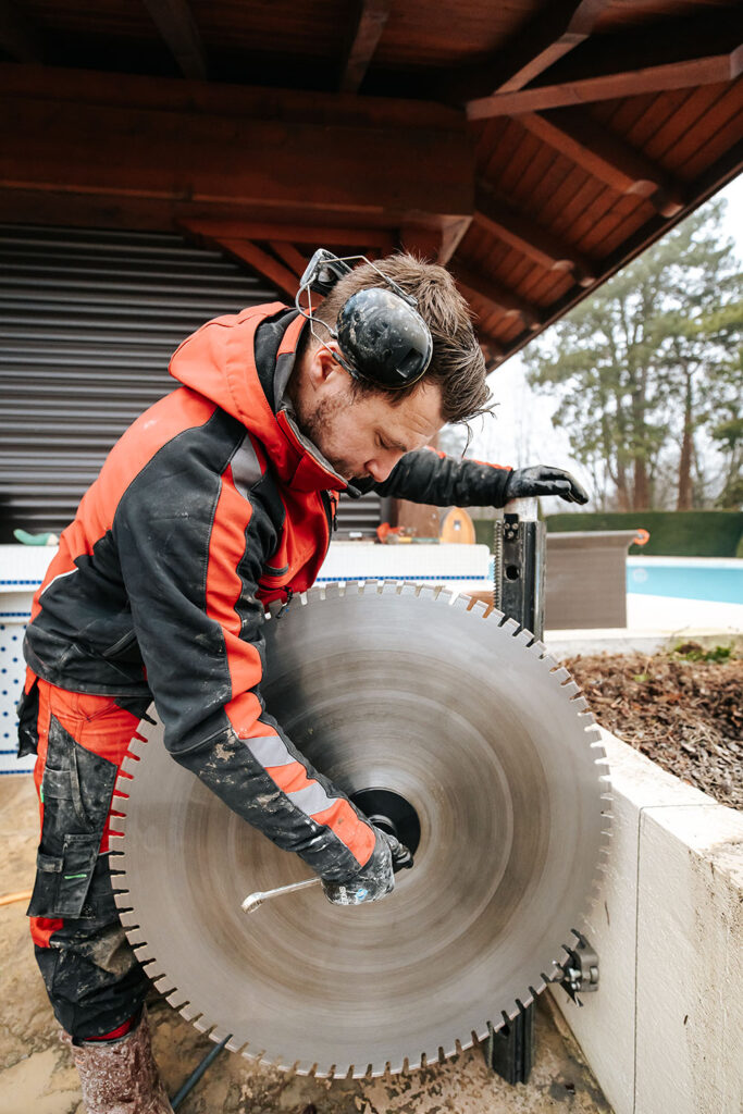 PHOTO D'UN PROFESSIONNEL DU SCIAGE BÉTON ENTRAIN D'INSTALLER UNE SCIE CIRCULAIRE